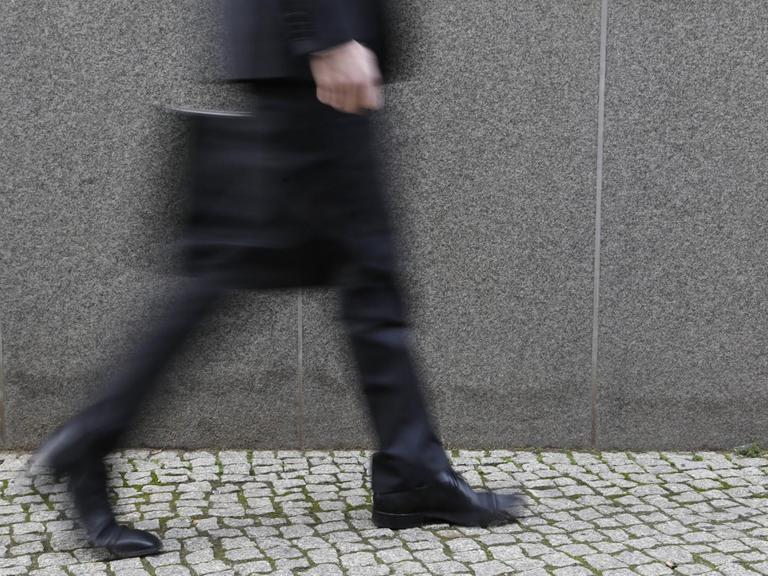 Geschäftsmann mit Aktenkoffer läuft auf der Straße