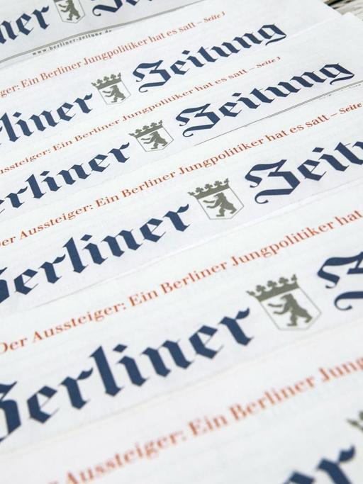 Ausgaben der "Berliner Zeitung" liegen aufgereiht auf einem Tisch.