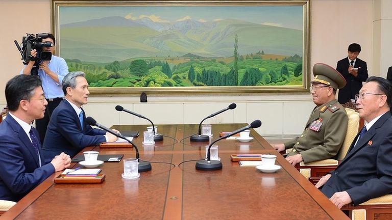 Vertreter von Süd- und Nord-Korea sitzen sich an einem Tisch gegenüber. Sie beraten über die Krise zwischen beiden Ländern. Vertreter von Süd- und Nord-Korea sitzen sich an einem Tisch gegenüber. Sie beraten über die Krise zwischen beiden Ländern.