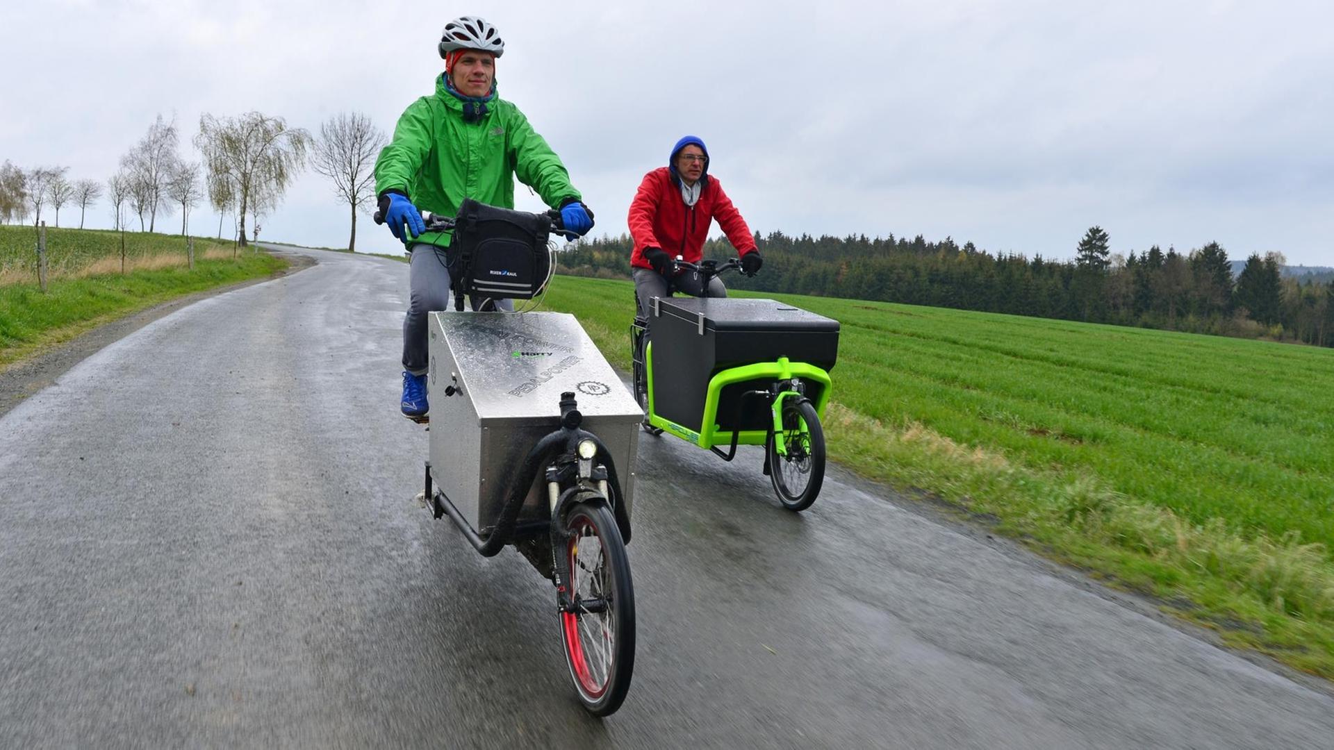 Bei einem Test von E-Lastenfahrrädern fahren Tester auf zwei speziellen E-Bikes. Bei einem Test von E-Lastenfahrrädern fahren Tester auf zwei speziellen E-Bikes.