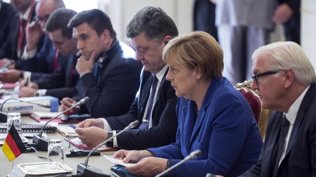 Bundesaußenminister Frank-Walter Steinmeier, Bundeskanzlerin Angela Merkel und der ukrainische Präsident Petro Poroschenko beraten beim Ukraine-Gipfel in Paris.
