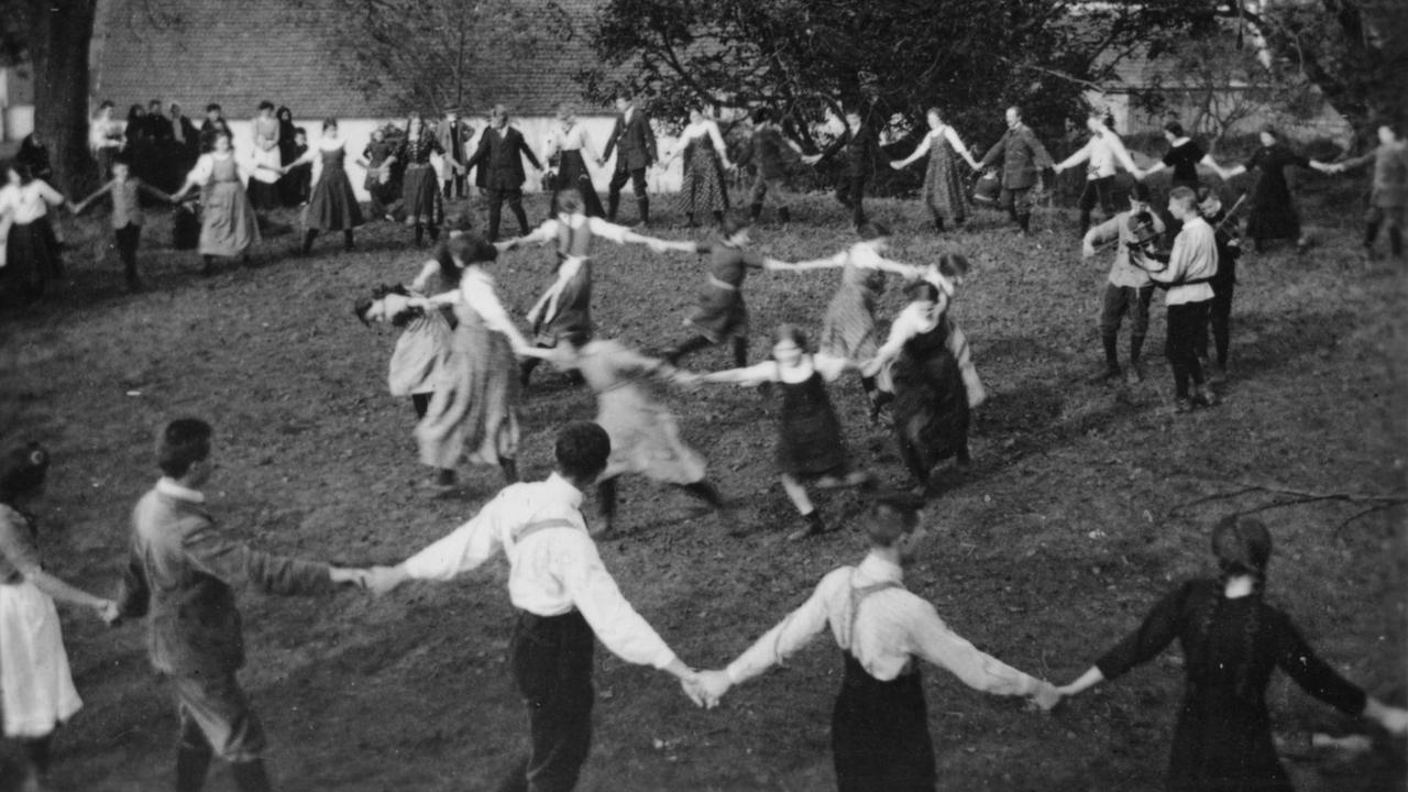 Jugendliche der Bewegung Wandervögel beim Ringelreihen auf einer Wiese um 1920. 