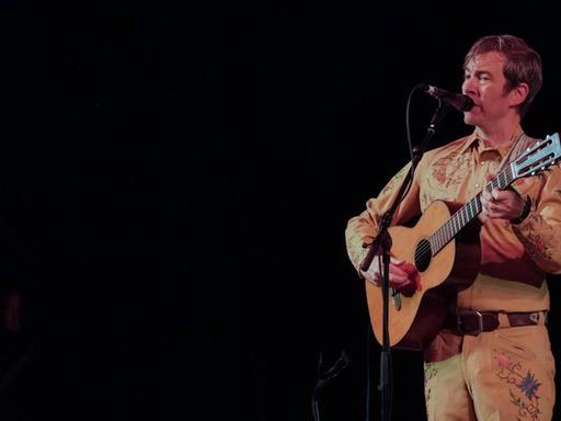 Bill Callahan mit Akustikgitarre auf einer Bühne