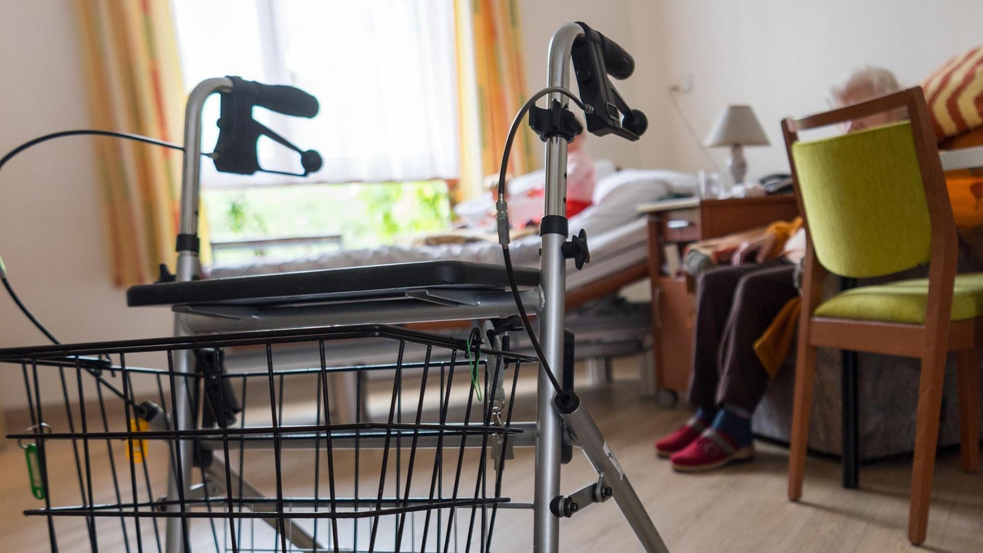 Ein Rollator steht im Zimmer einer älteren Frau Ein Rollator steht im Zimmer einer älteren Frau