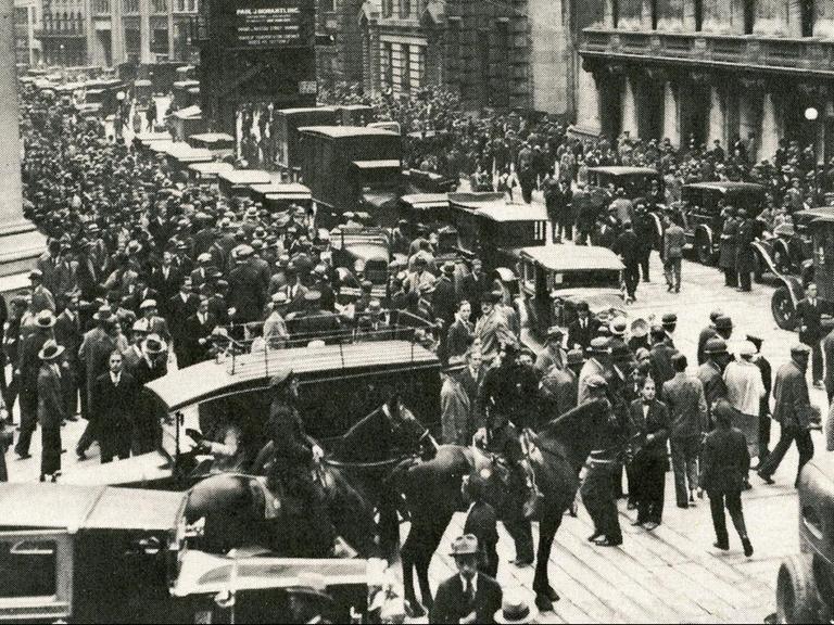 Menschenmassen sammeln sich vor der New Yorker Börse nach dem Kurssturz. Polizisten stehen dabei.