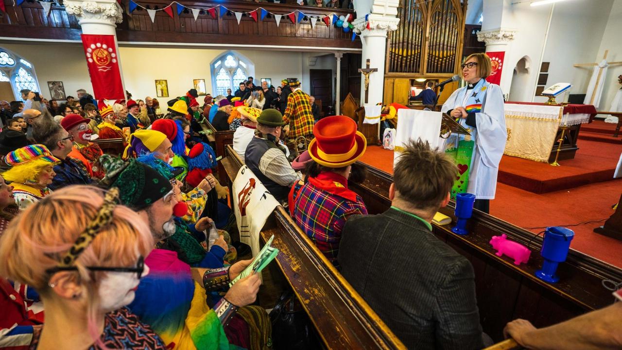 Laura "Joy" Fawcett beim Joseph-Grimaldi-Gedenkgottesdienst in London. In den Kirchenbänke sitzen bunte Clowns Laura "Joy" Fawcett beim Joseph-Grimaldi-Gedenkgottesdienst in London. In den Kirchenbänke sitzen bunte Clowns