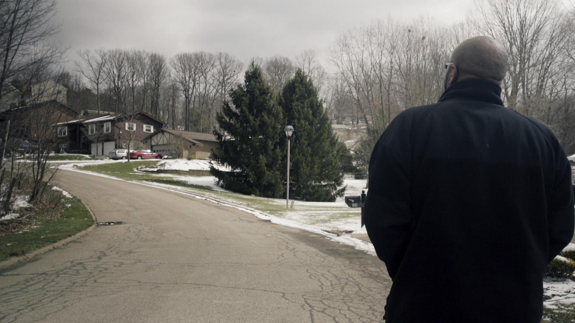 Ein Mann läuft eine Straße in einer amerikanischen Wohnsiedlung entlang. Zu sehen ist er nur von hinten. Ein Mann läuft eine Straße in einer amerikanischen Wohnsiedlung entlang. Zu sehen ist er nur von hinten.
