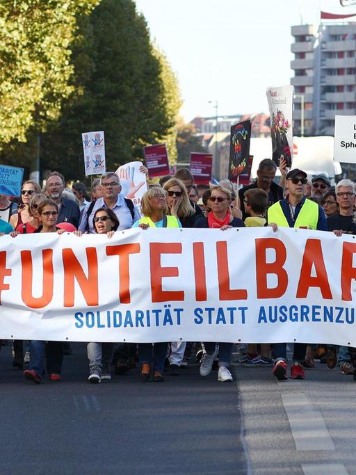 Teilnehmer der Demonstration unter dem Motto "Unteilbar Solidarität statt Ausgrenzung" tragen an der Spitze der Demo ein Transparent.