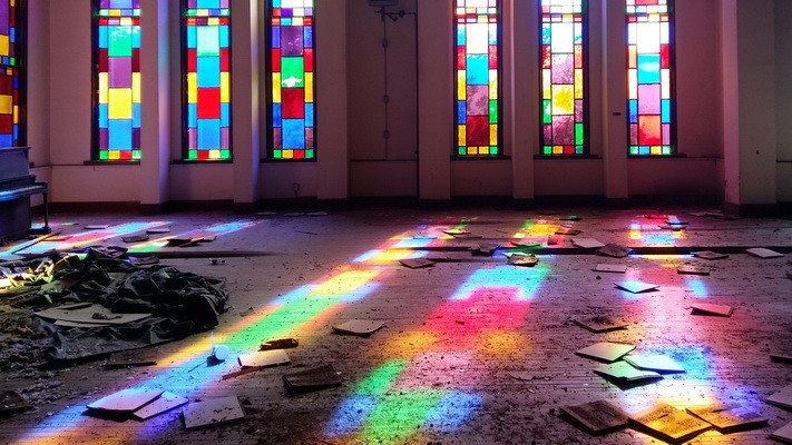 Sonnenstrahlen fallen durch die farbigen Bleiglasfenster des Auditorium der Mississippi University for Women und erzeugen bunte Muster auf der Bühne, die von Scherben übersät ist. Sonnenstrahlen fallen durch die farbigen Bleiglasfenster des Auditorium der Mississippi University for Women und erzeugen bunte Muster auf der Bühne, die von Scherben übersät ist.