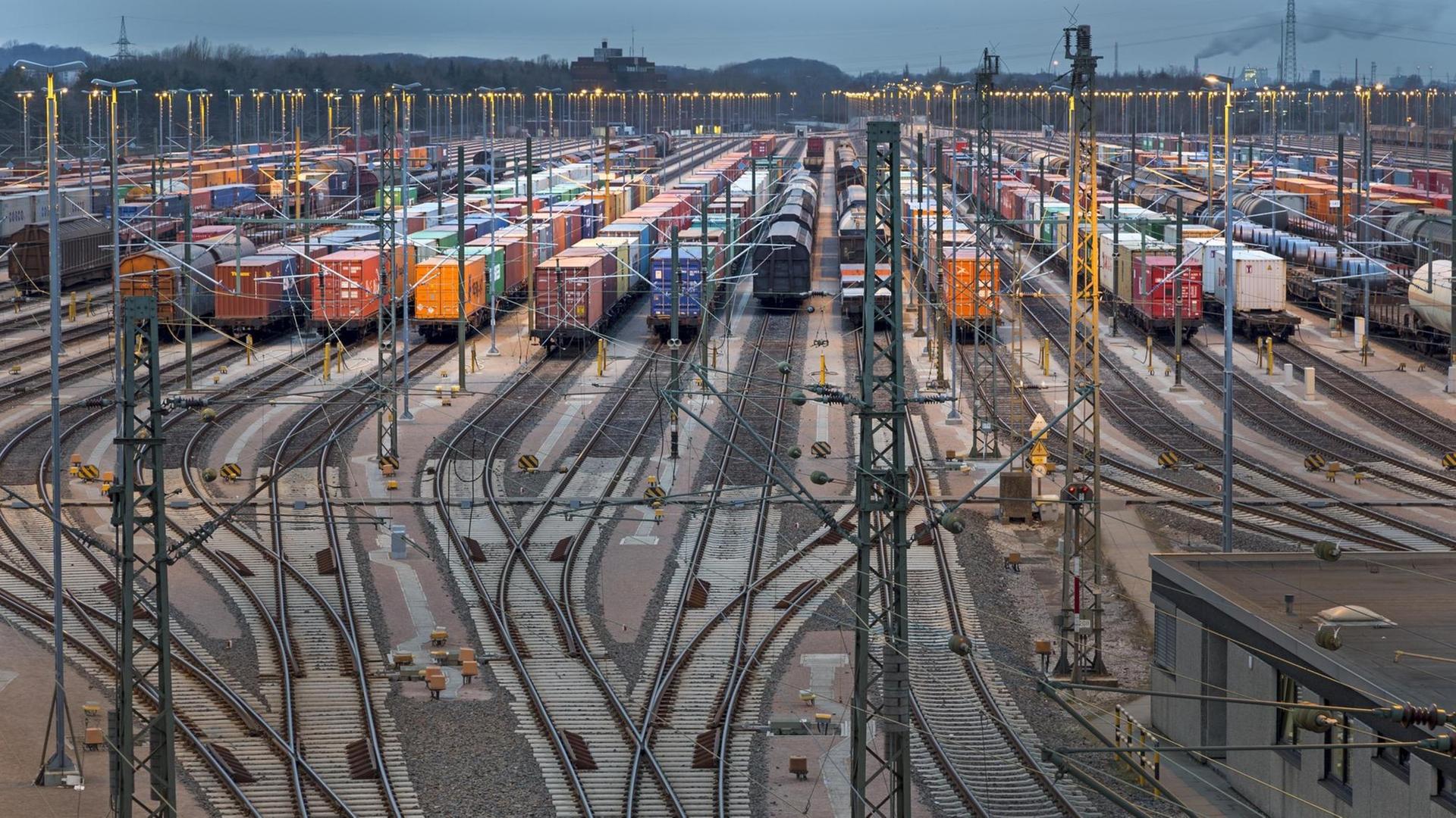 Abgestellte Güterwaggons auf Gleisen bei Dämmerung auf dem Rangierbahnhof Maschen in Niedersachsen Abgestellte Güterwaggons auf Gleisen bei Dämmerung auf dem Rangierbahnhof Maschen in Niedersachsen