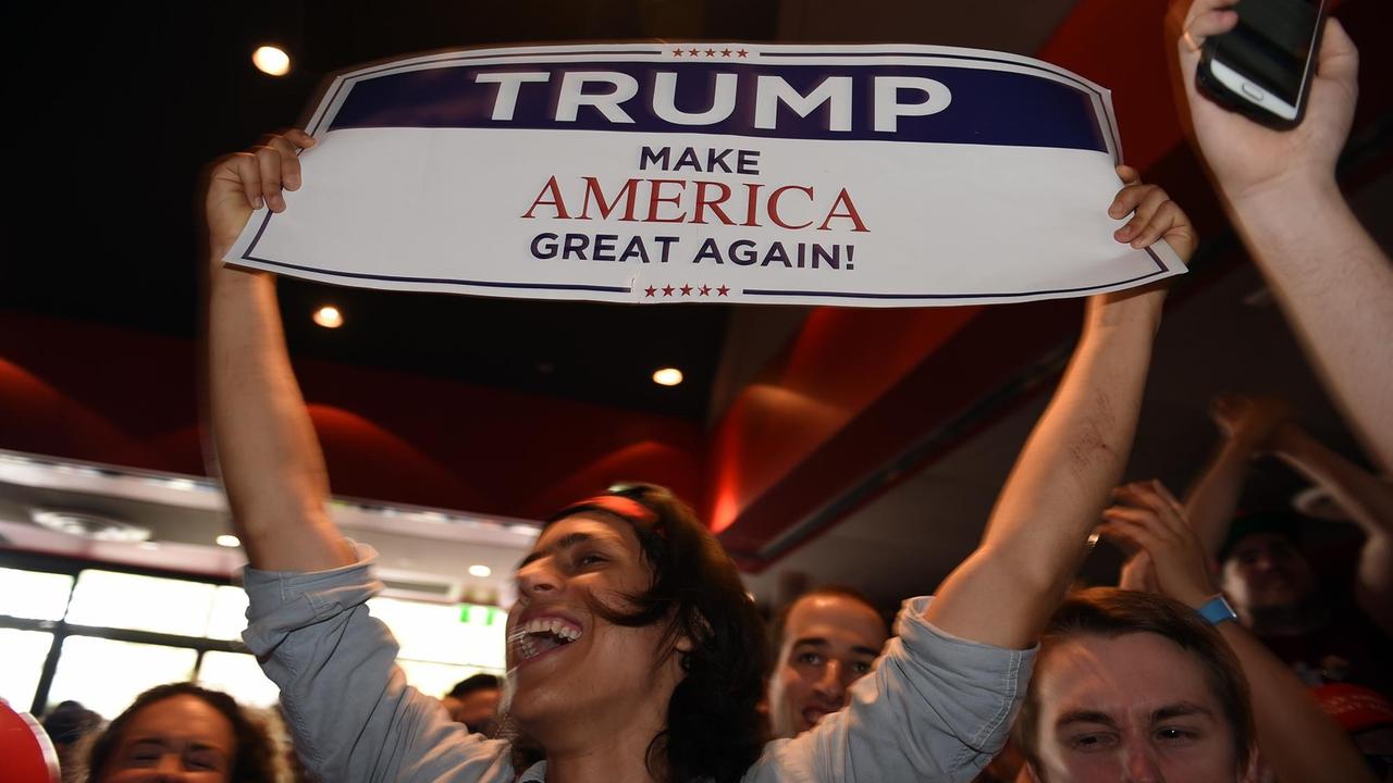 Unterstützer von Donald Trump in Sydney/Australien halten ein Plakat mit "Trump - Make America Great Again" hoch. Unterstützer von Donald Trump in Sydney/Australien halten ein Plakat mit "Trump - Make America Great Again" hoch.