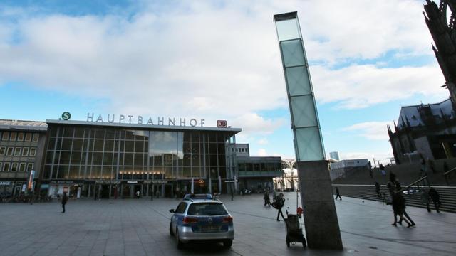 Man sieht den Kölner Hauptbahnhof tagsüber, im Vordergrund ein Polizeiauto.