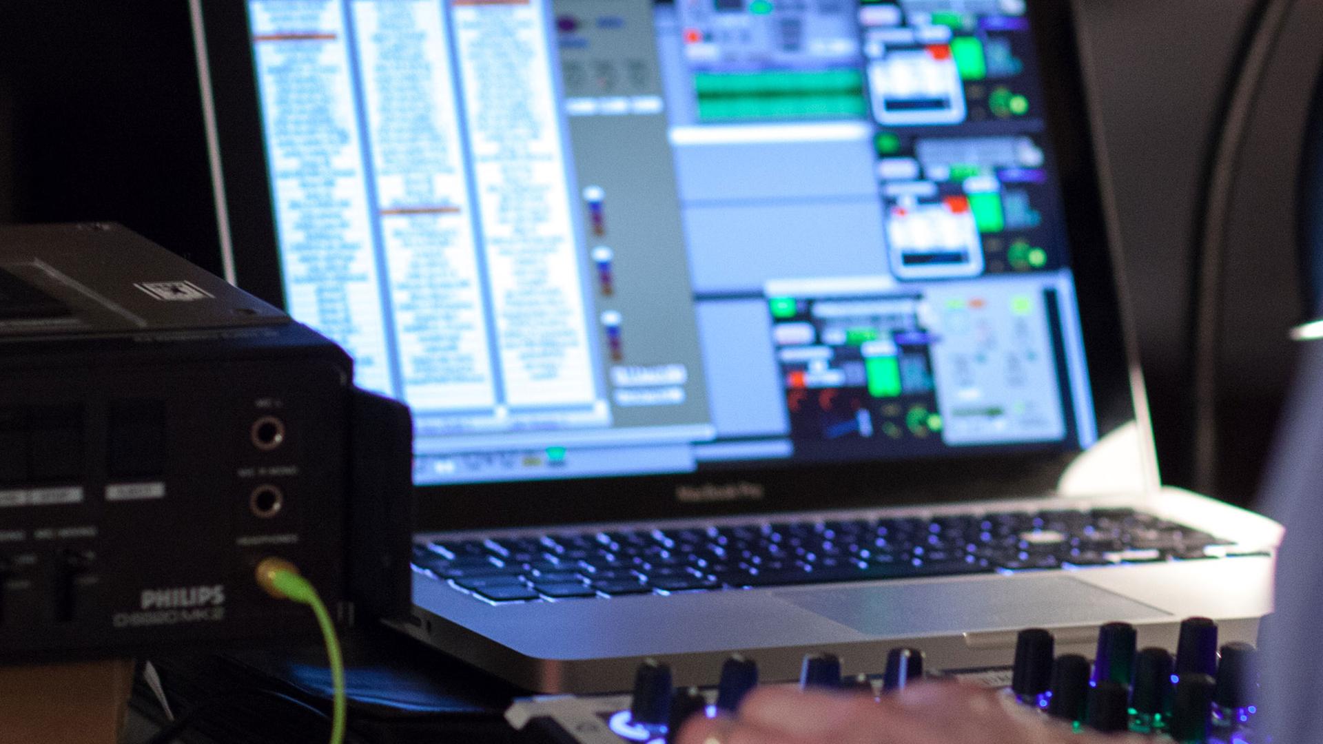 Ein Soundkünstler improvisiert Klangskulpturen mit Mischpult und Computer. Ein Soundkünstler improvisiert Klangskulpturen mit Mischpult und Computer.