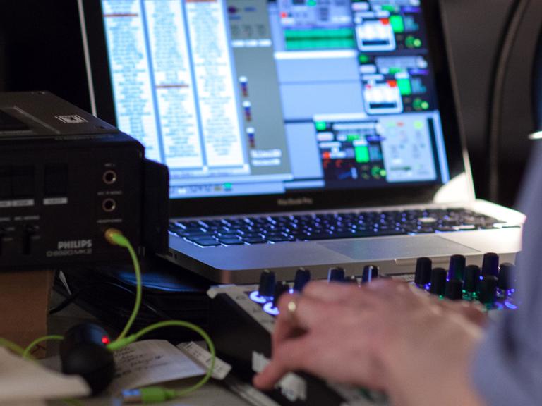 Ein Soundkünstler improvisiert Klangskulpturen mit Mischpult und Computer.