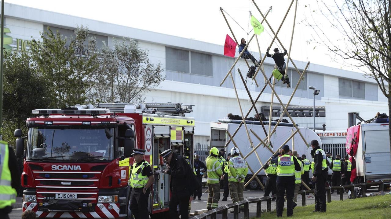 Aktivisten von Extinction Rebellion blockieren die Zufahrtsstraße zu einer Druckerei. Aktivisten von Extinction Rebellion blockieren die Zufahrtsstraße zu einer Druckerei.