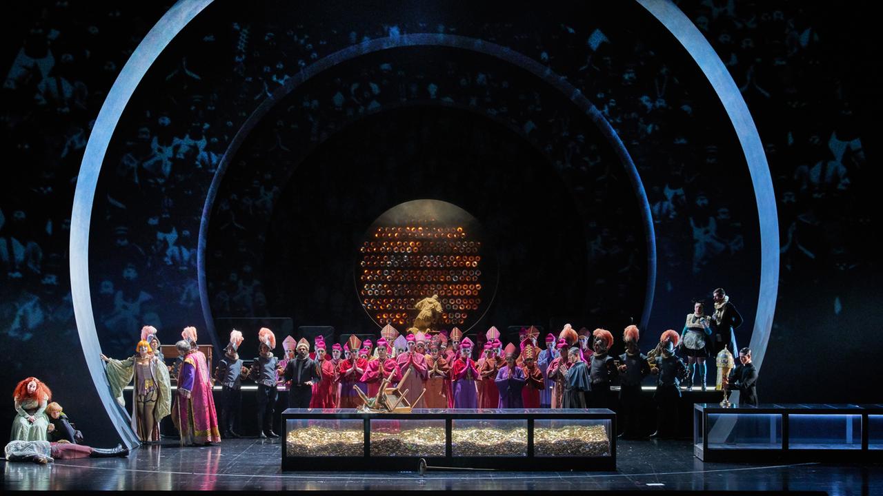 Eine Szene der Oper "Beatrice Cenci" bei den Bregenzer Festspielen: In Rot gekleidete Kardinäle stehen vor einem Sarg aus Glas voll Geldmünzen.