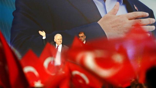 Blick aus dem Publikum: Der türkische Ministerpräsident Binali Yildirim steht auf einer Bühne und verabschiedet sich nach seiner Rede von den Besuchern. Er winkt, die Zuschauer schwenken türkische Fahnen.