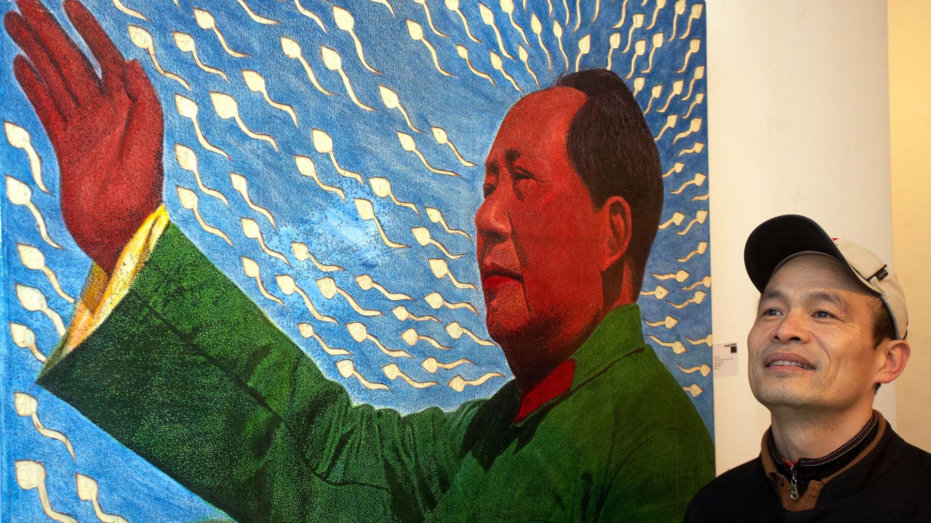 Der chinesische Künstler Ren Rong, der in Bonn und Peking lebt, posiert am Sonntag (14.2.2010) bei der Eröffnung seiner Ausstellung in der Kunsthalle Koblenz vor einem Bild mit dem Titel "Pflanzenmensch/ Mao 2007".