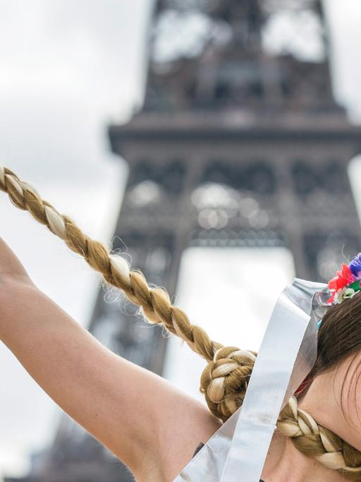 Eine Frau protestiert vor dem Pariser Eifelturm