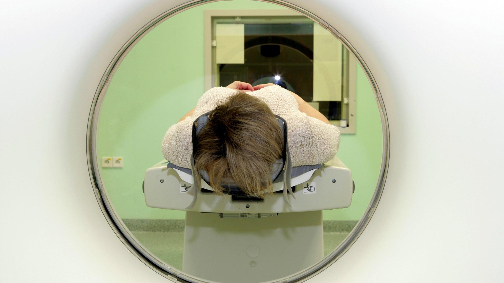 Eine Frau auf der Liege eines Computertomographen im Krankenhaus Eine Frau auf der Liege eines Computertomographen im Krankenhaus