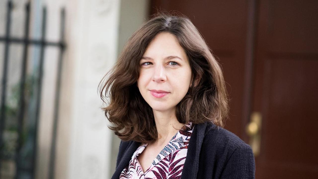 Lina Muzur steht vor einer braunen Tür und schaut in die Kamera. Lina Muzur steht vor einer braunen Tür und schaut in die Kamera.