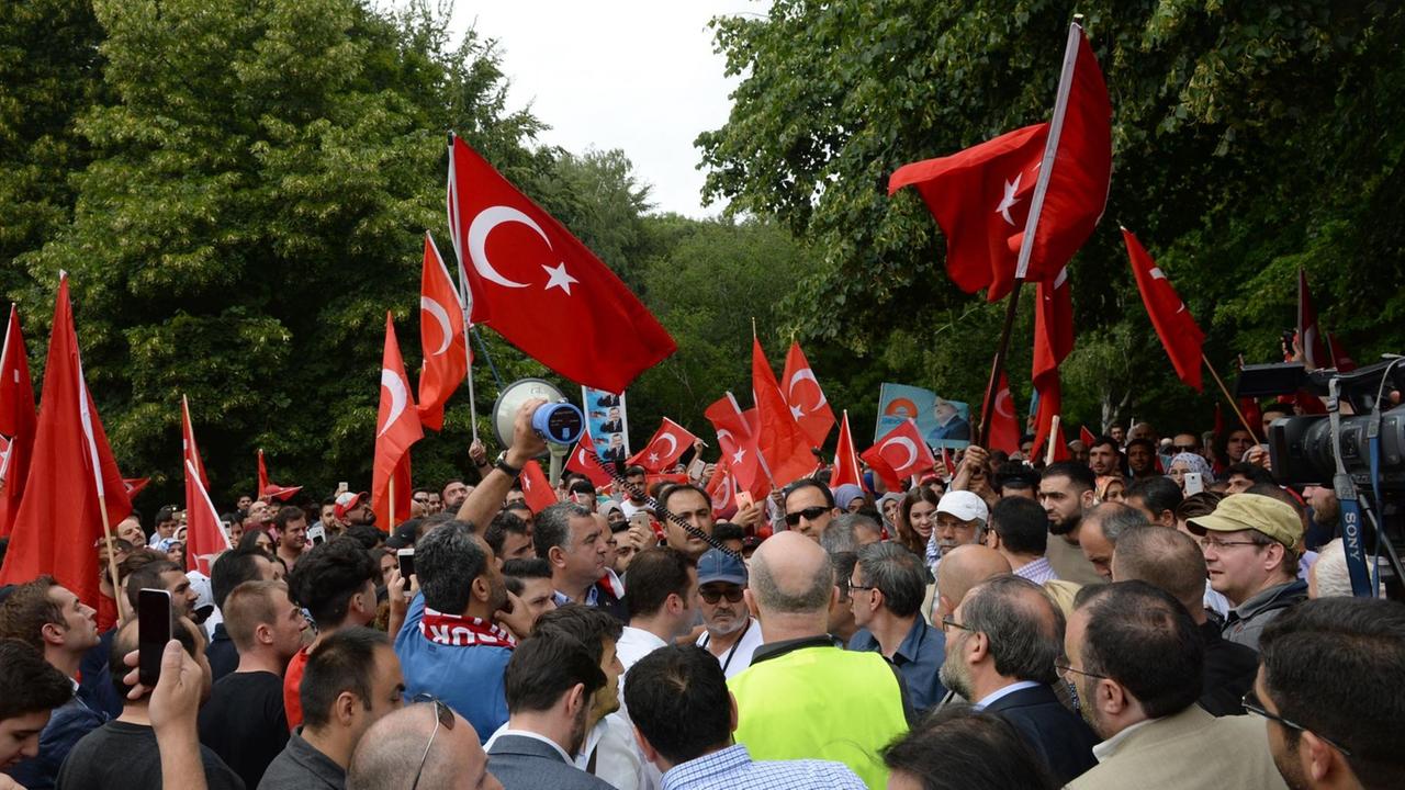 Demonstranten stehen am 16.07.2016 in Berlin mit türkischen Fahnen vor dem Botschaftsgebäude der Türkei. Nach Angaben der Polizei demonstrierten dort 500 Menschen gegen den Putschversuch des türkischen Militärs. Demonstranten stehen am 16.07.2016 in Berlin mit türkischen Fahnen vor dem Botschaftsgebäude der Türkei. Nach Angaben der Polizei demonstrierten dort 500 Menschen gegen den Putschversuch des türkischen Militärs.