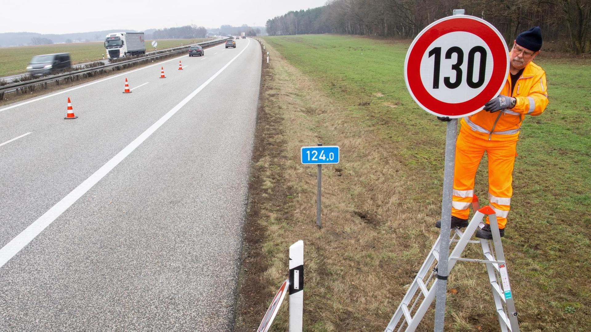 An der A24 bei Suckow (Mecklenburg-Vorpommern) wird ein Straßenschild mit der Geschwindigkeitsangabe 130 km/h montiert.