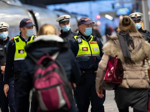 Sicherheitsmitarbeiter der Deutsche Bahn kontrollieren zusammen mit Polizisten der Bundespolizei die Einhaltung der Maskenpflicht am Hauptbahnhof in München.