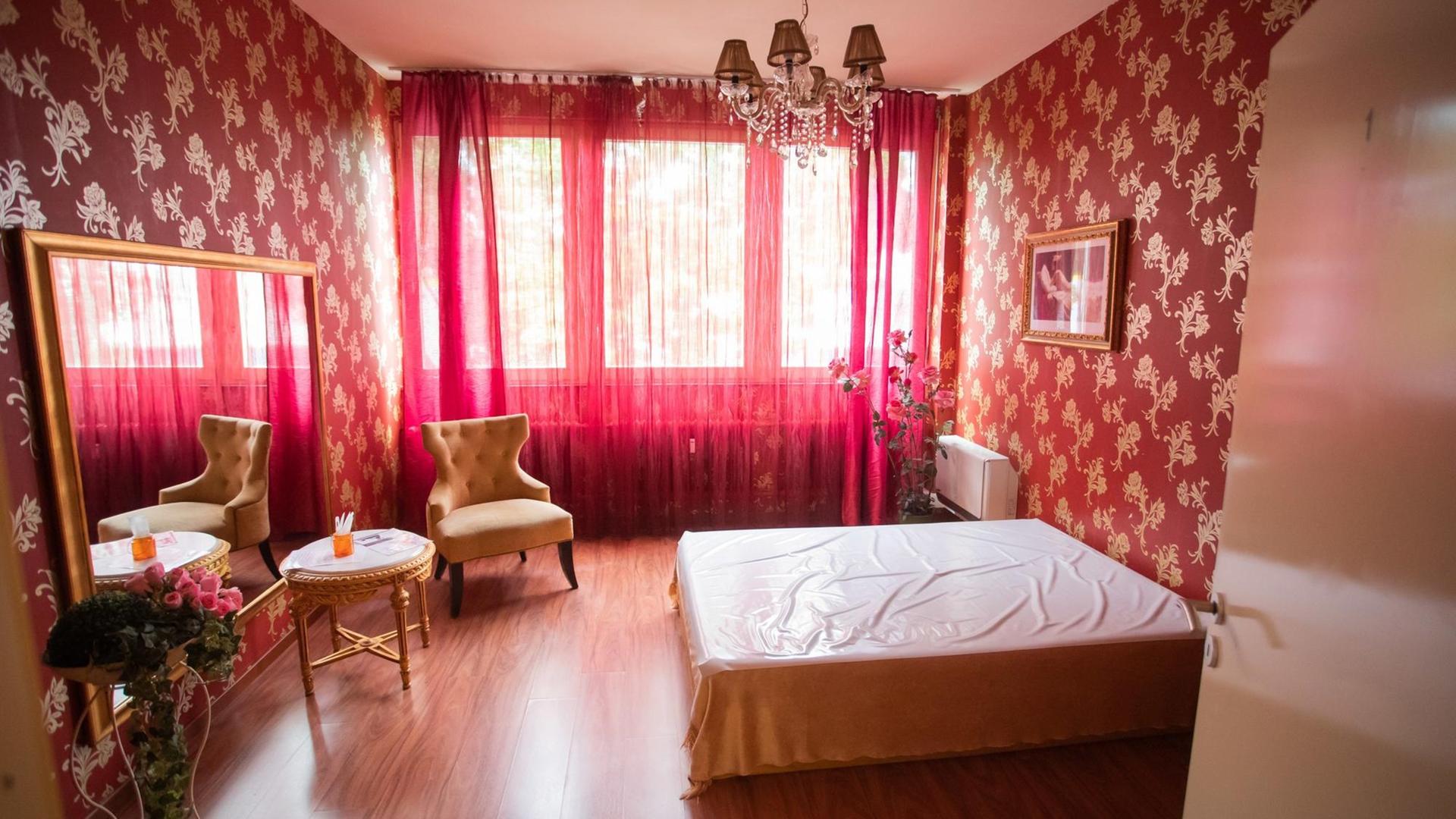 Blick in ein leeres, rosafarbenes Bordellzimmer mit geschlossenen Gardinen Blick in ein leeres, rosafarbenes Bordellzimmer mit geschlossenen Gardinen