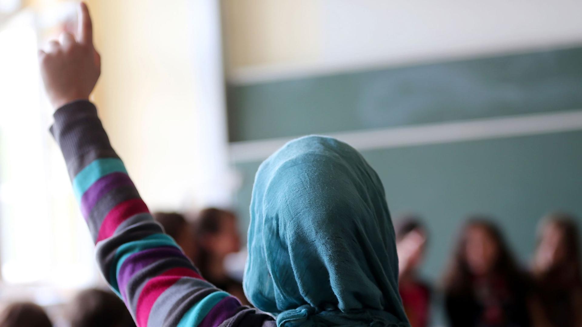 Eine Schülerin mit Kopftuch aus der Türkei meldet sich im Unterricht am 10.06.2013 in Oberhausen (Nordrhein-Westfalen) Eine Schülerin mit Kopftuch aus der Türkei meldet sich im Unterricht am 10.06.2013 in Oberhausen (Nordrhein-Westfalen)