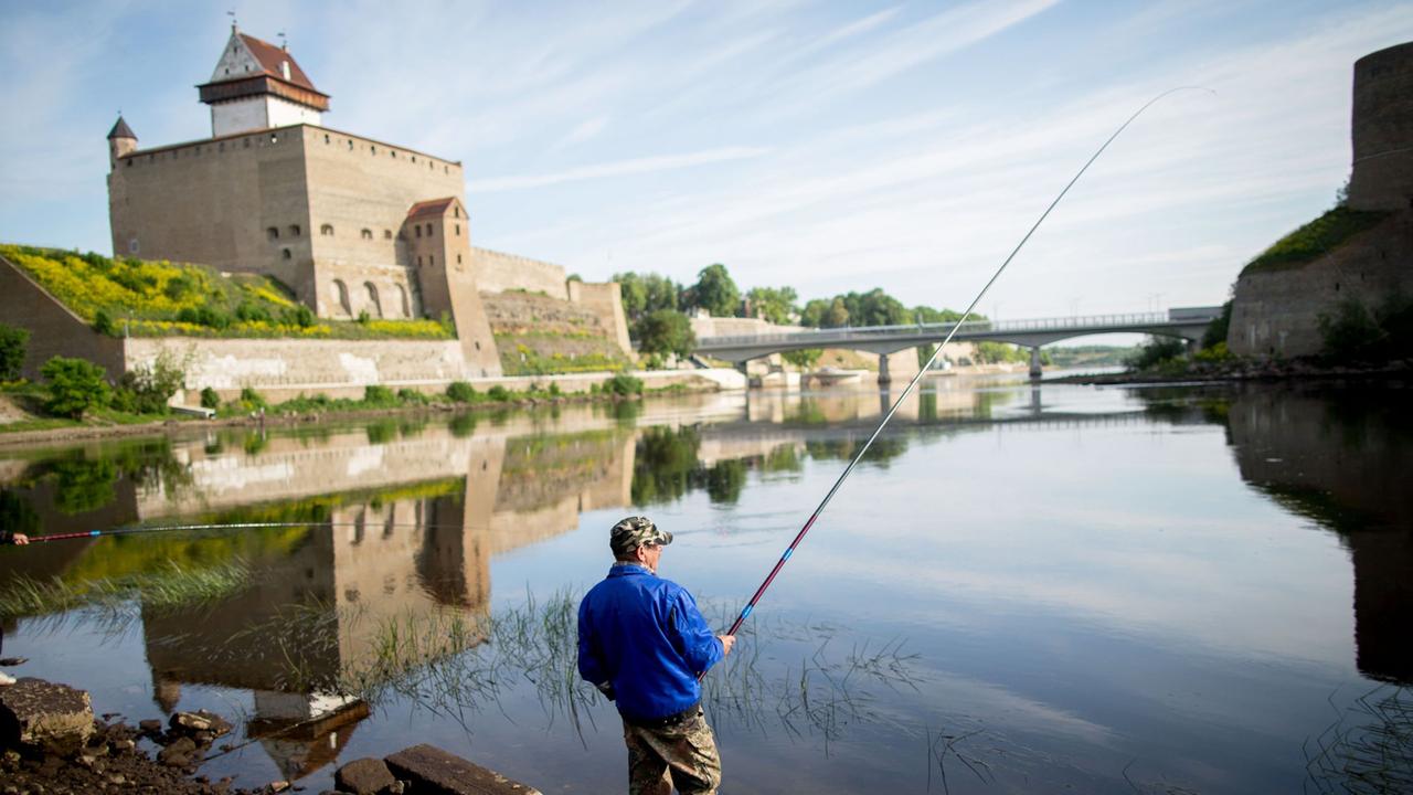 Die Grenze zwischen Estland und Russland markiert der Fluss Narva. 2 Angler sind zu sehen. Links ist die estnische Hermannsfeste und rechts die russische Burg Iwangorod. Die Grenze zwischen Estland und Russland markiert der Fluss Narva. 2 Angler sind zu sehen. Links ist die estnische Hermannsfeste und rechts die russische Burg Iwangorod.