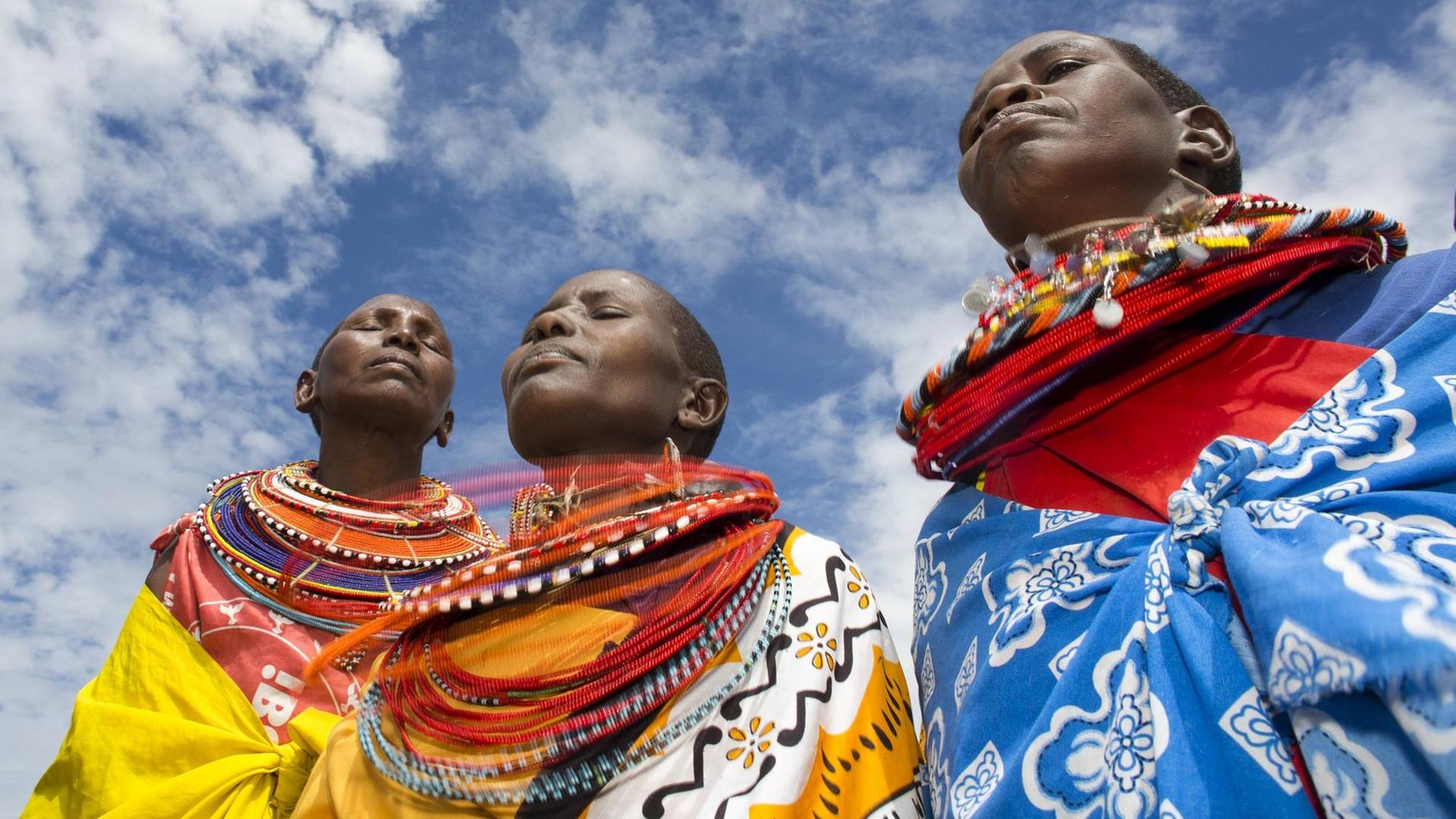 Drei Angehörige der nordkenianischen Samburu tragen traditionelle Kleidung. Drei Angehörige der nordkenianischen Samburu tragen traditionelle Kleidung.