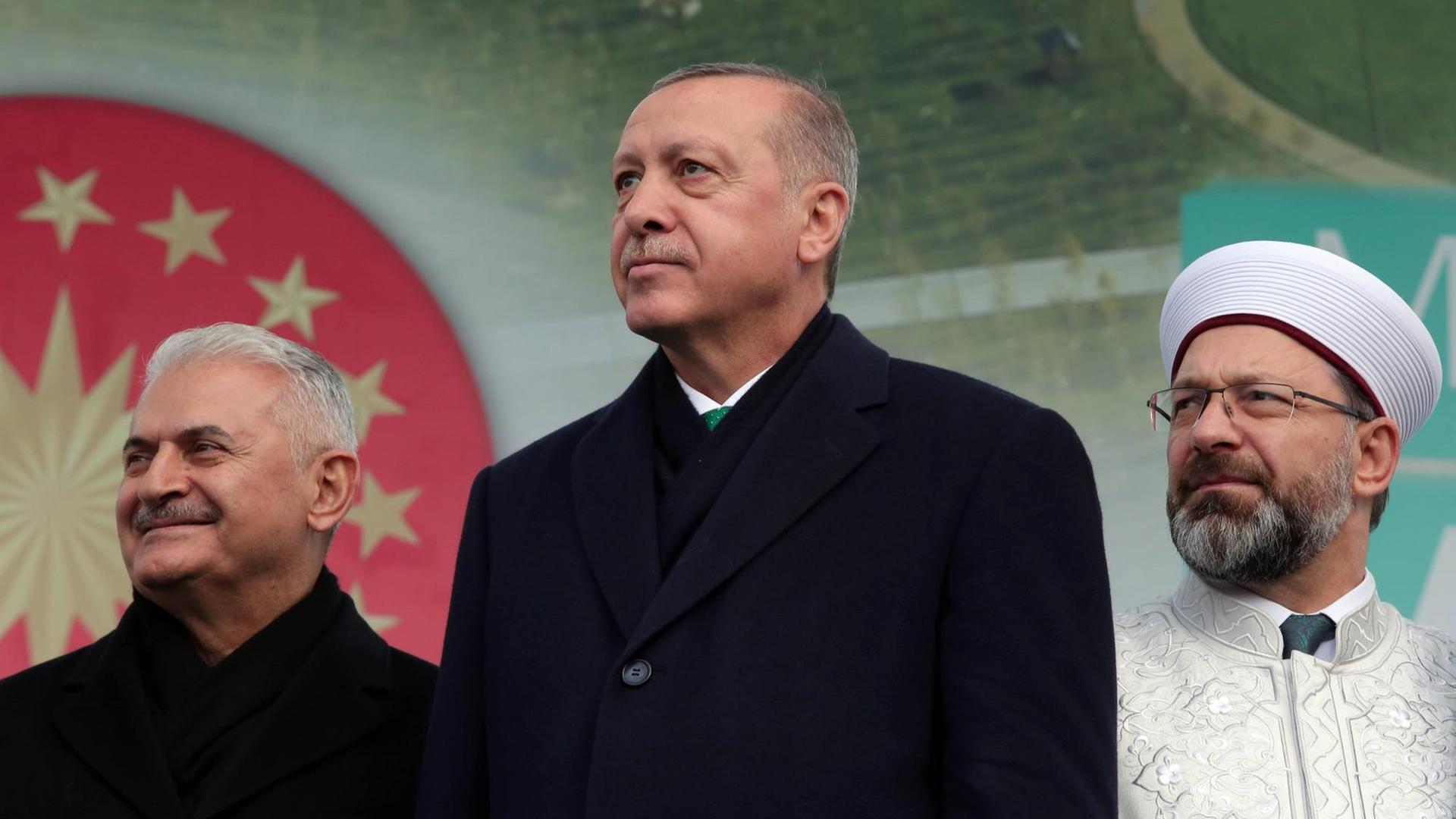 Präsident Erdogan bei einer Eröffnungsrede für einen öffentlichen Garten in Istanbul. Hinter ihm stehen Parlamentssprecher Binali Yildirim (l.) und das Oberhaupt der türkischen Religionsbehörde Diyanet, Ali Erbas (r.) (Foto vom 17.11.2018) Präsident Erdogan bei einer Eröffnungsrede für einen öffentlichen Garten in Istanbul. Hinter ihm stehen Parlamentssprecher Binali Yildirim (l.) und das Oberhaupt der türkischen Religionsbehörde Diyanet, Ali Erbas (r.) (Foto vom 17.11.2018)