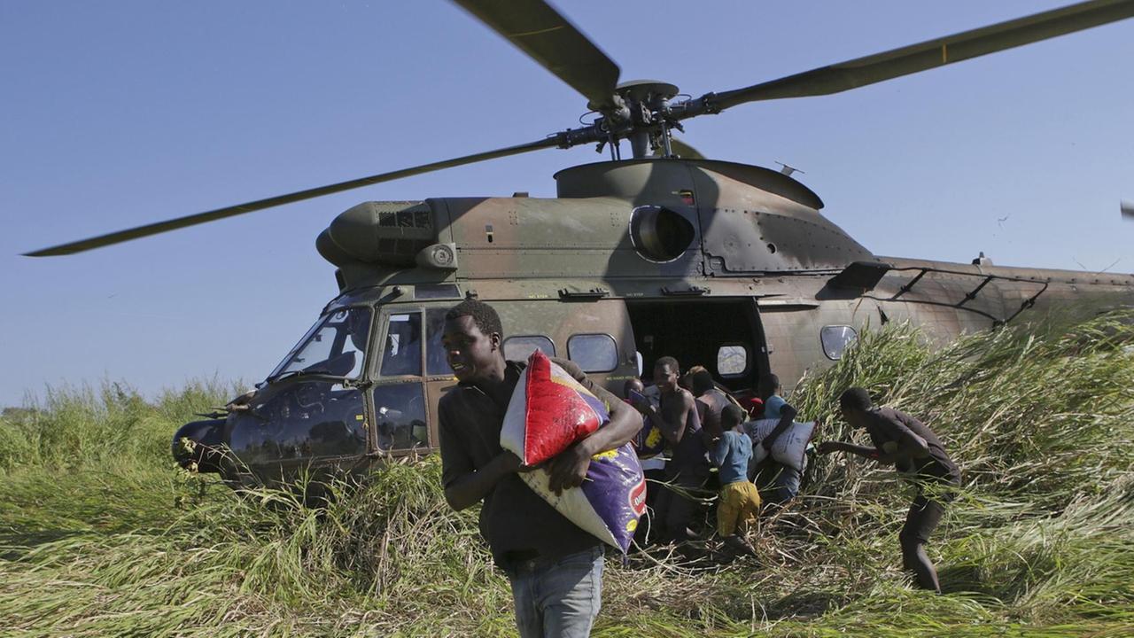 Im März 2019 warten Einwohner von Gwaragwara in Mosambik auf Reis, der aus einem Hubschrauber der South African Airforce verteilt wird - die Region wurde vom Zyklon Idai verwüstet. Im März 2019 warten Einwohner von Gwaragwara in Mosambik auf Reis, der aus einem Hubschrauber der South African Airforce verteilt wird - die Region wurde vom Zyklon Idai verwüstet.