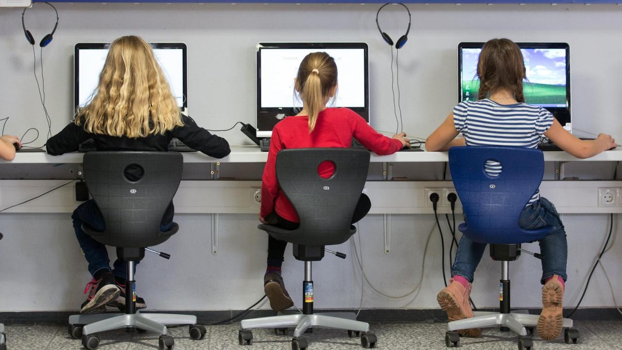 Schüler arbeiten in einem Klassenraum einer Grundschule an Computern. Schüler arbeiten in einem Klassenraum einer Grundschule an Computern.