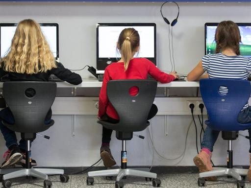 Schüler arbeiten in einem Klassenraum einer Grundschule an Computern.