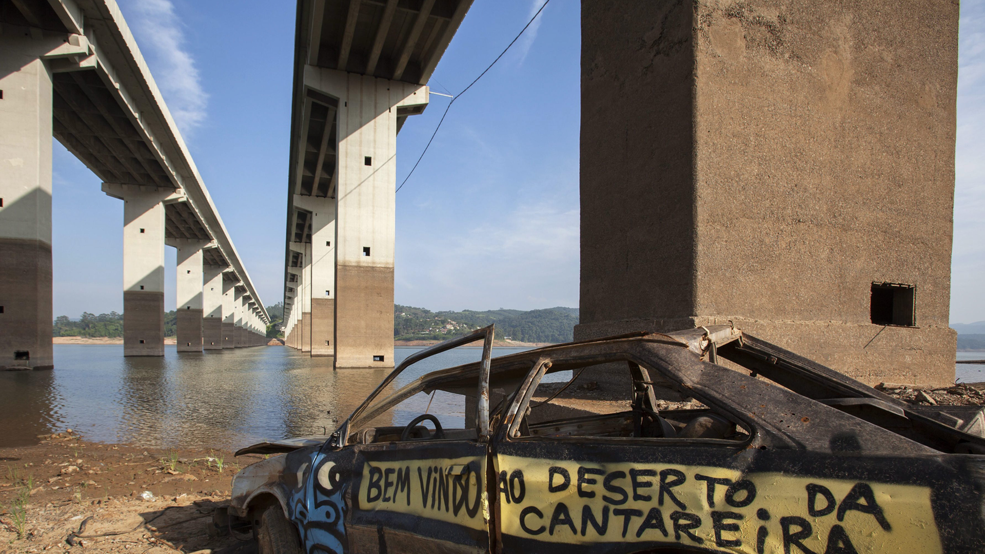 Brückenpfeiler und ein altes Autowrack sind an einem Fluss in Sao Paulo Brasilien zu sehen. Es herrscht eine große Dürre in Brasilien Brückenpfeiler und ein altes Autowrack sind an einem Fluss in Sao Paulo Brasilien zu sehen. Es herrscht eine große Dürre in Brasilien