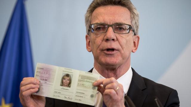 Bundesinnenminister Thomas de Maiziere (CDU) zeigt den neuen Flüchtlingsausweis.