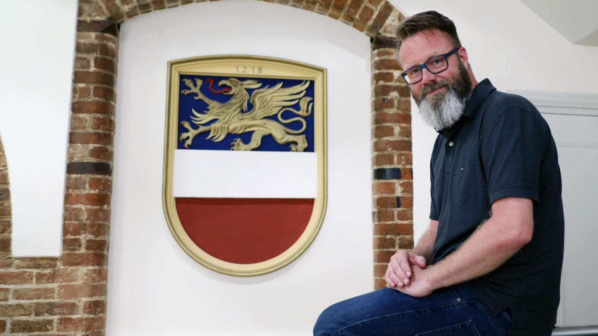 Claus Ruhe Madsen, Oberbürgermeister von Rostock, sitzt im Rathaus vor dem Stadtwappen. Claus Ruhe Madsen, Oberbürgermeister von Rostock, sitzt im Rathaus vor dem Stadtwappen.