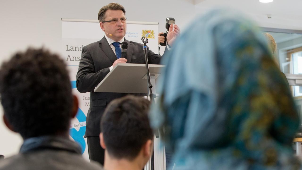 Bayerns Justizminister Winfried Bausback spricht in einer Berufsschule vor Flüchtlingen Bayerns Justizminister Winfried Bausback spricht in einer Berufsschule vor Flüchtlingen
