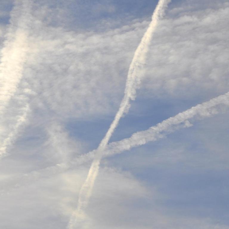 Am Himmel verteilen sich die nur langsam auflösenden Kondensstreifen zahlreicher Flugzeuge, die im Laufe des Morgens über der Region unterwegs waren