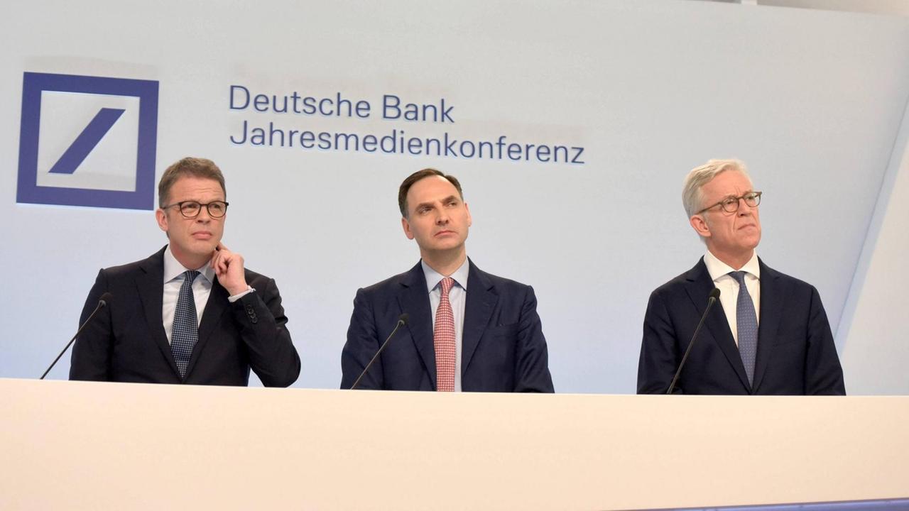 Während der Jahresbilanzpressekonferenz der Deutschen Bank stehen Vorstandsvorsitzender Christian Sewing, Finanzvorstand James von Moltke und stellvertretender Vorsitzender Karl von Rohr nebeneinander.