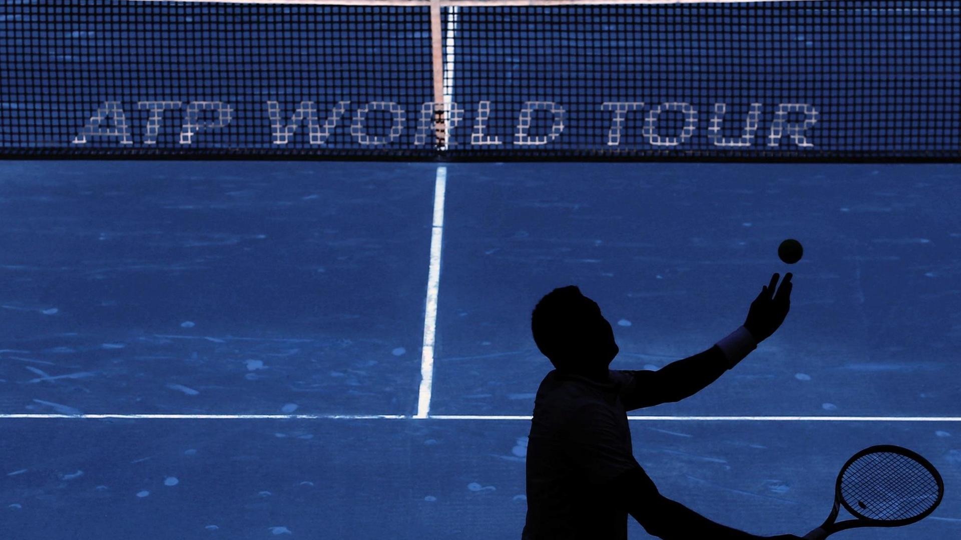 Ein Tennisspieler schlägt vor dem Netz mit der Aufschrift "ATP World Tour" in Madrid auf. Ein Tennisspieler schlägt vor dem Netz mit der Aufschrift "ATP World Tour" in Madrid auf.