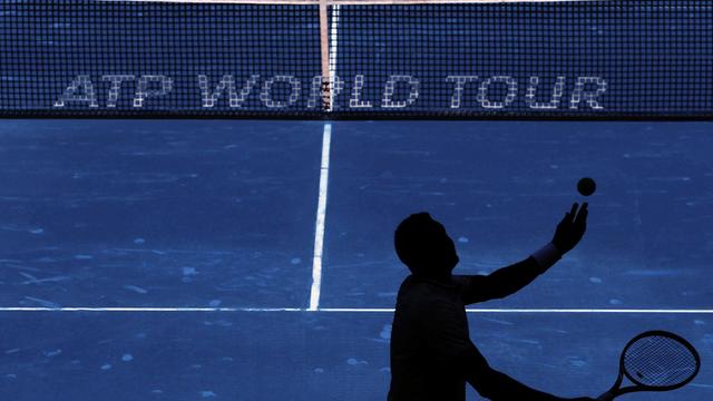 Ein Tennisspieler schlägt vor dem Netz mit der Aufschrift "ATP World Tour" in Madrid auf.