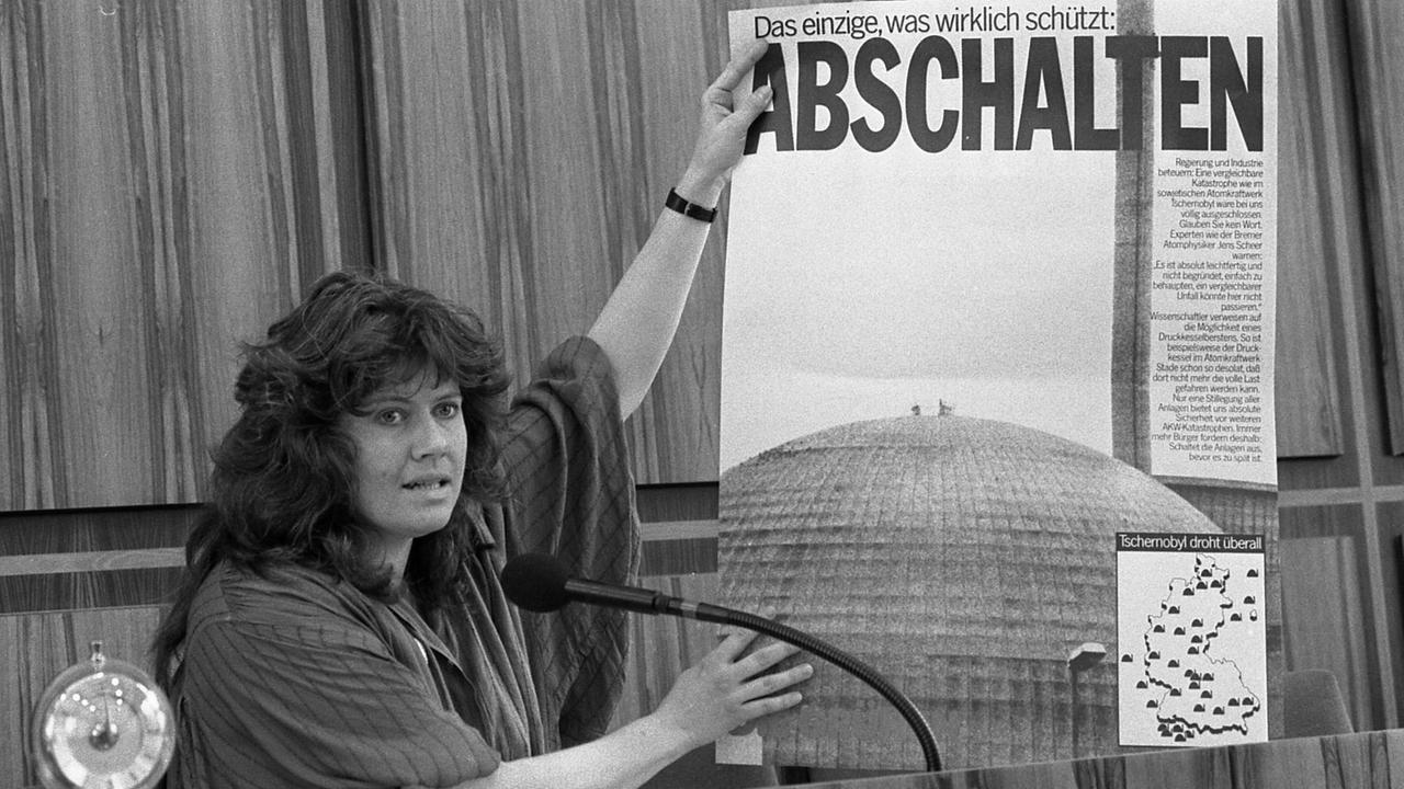 Jutta Ditfurth 1986 - noch als Mitglied der Grünen - vor einem Banner, auf dem steht: "Das Einzige, was wirklich schützt: Abschalten."