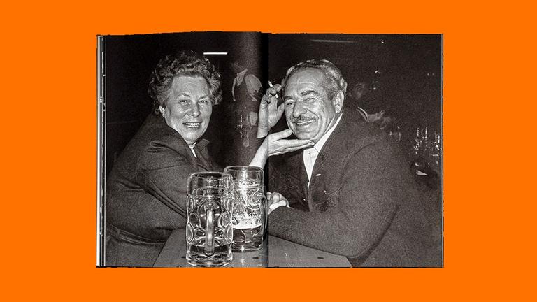 Das Bild zeigt eine Doppelseite aus einem Fotoband: Ein älteres Paar sitzt mit Biergläsern an einem Biertisch. Die Frau streicht dem Mann übers Kinn. Das Bild zeigt eine Doppelseite aus einem Fotoband: Ein älteres Paar sitzt mit Biergläsern an einem Biertisch. Die Frau streicht dem Mann übers Kinn.