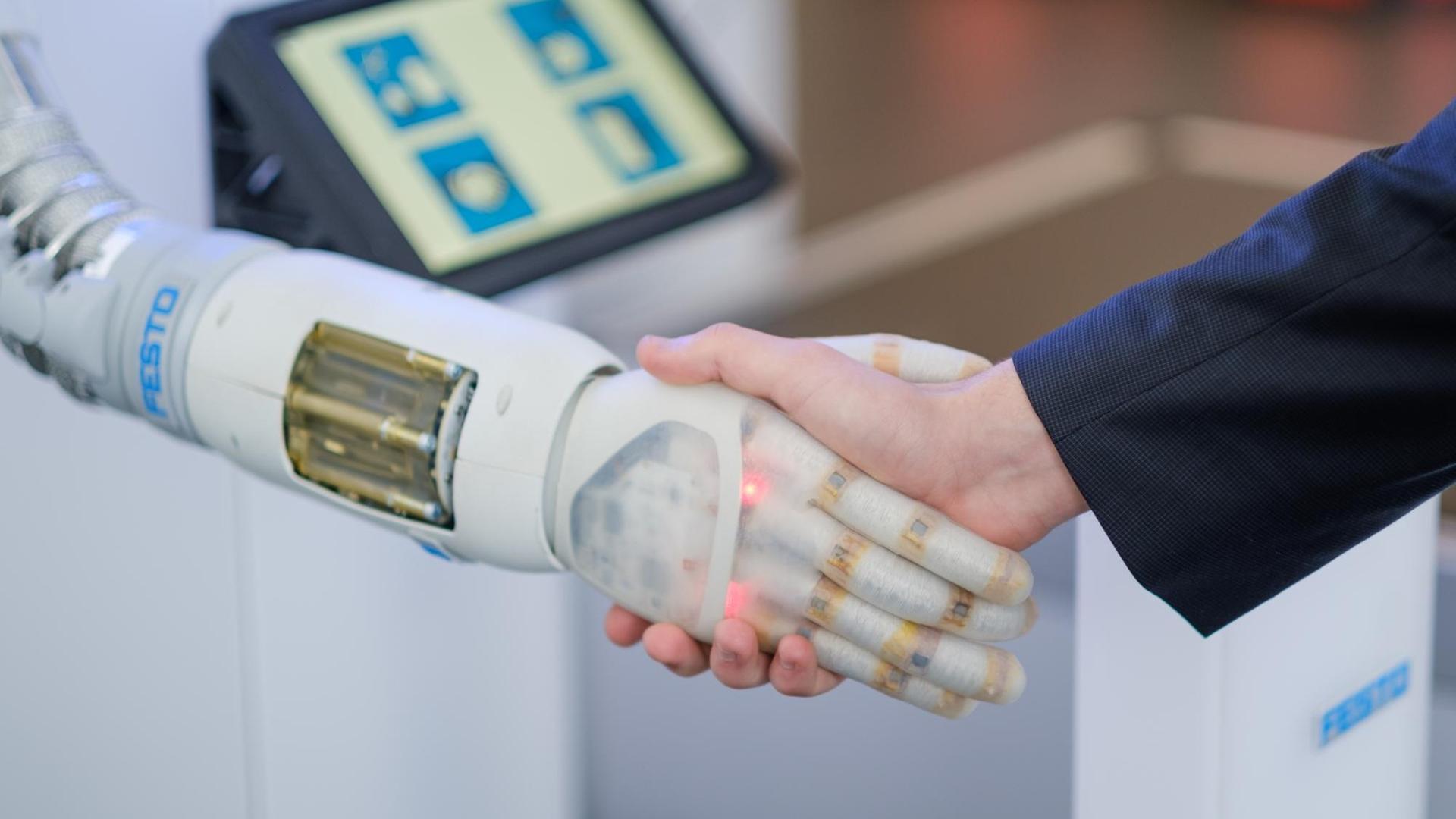 , Niedersachsen, Hannover: Ein Mitarbeiter der Firma Festo schüttelt vor Beginn einer Pressekonferenz zur Hannover Messe zum Thema digitaler Wandel in der Industrie die pneumatisch betriebene Roboter Hand „Bionic Soft Hand“ der Firma Festo. , Niedersachsen, Hannover: Ein Mitarbeiter der Firma Festo schüttelt vor Beginn einer Pressekonferenz zur Hannover Messe zum Thema digitaler Wandel in der Industrie die pneumatisch betriebene Roboter Hand „Bionic Soft Hand“ der Firma Festo.