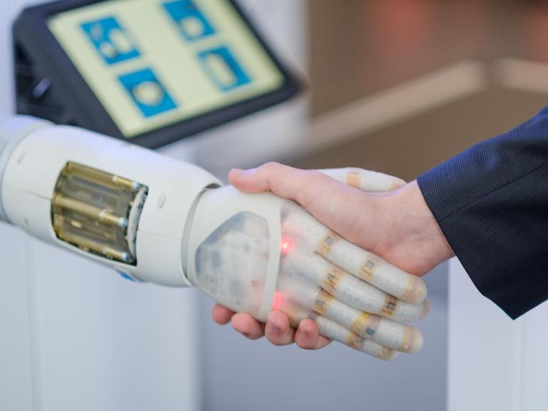 , Niedersachsen, Hannover: Ein Mitarbeiter der Firma Festo schüttelt vor Beginn einer Pressekonferenz zur Hannover Messe zum Thema digitaler Wandel in der Industrie die pneumatisch betriebene Roboter Hand „Bionic Soft Hand“ der Firma Festo.