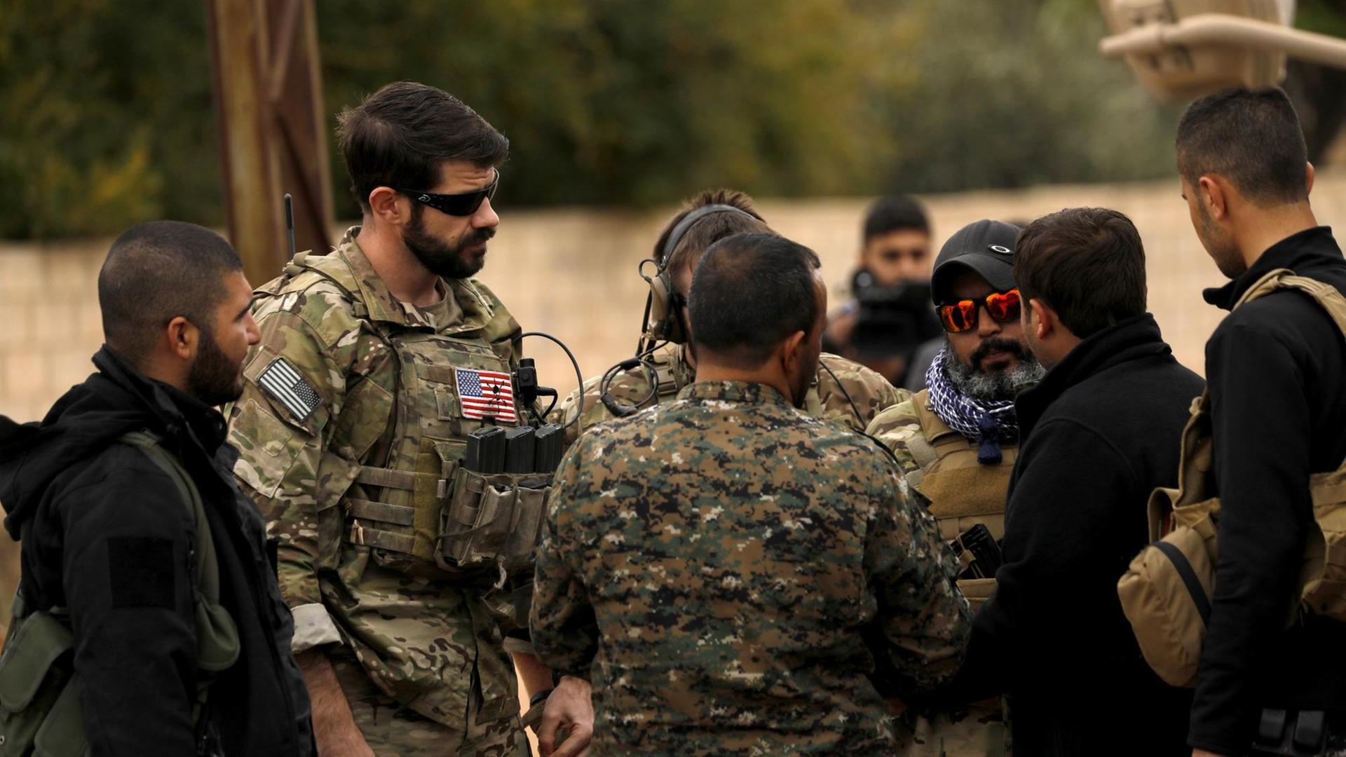 Das Foto zeigt Kämpfer der Syrischen Demokratischen Kräfte (SDF) und US-Soldaten in Al-Darbasiyah in Nordost-Syrien im November 2018. Das Foto zeigt Kämpfer der Syrischen Demokratischen Kräfte (SDF) und US-Soldaten in Al-Darbasiyah in Nordost-Syrien im November 2018.