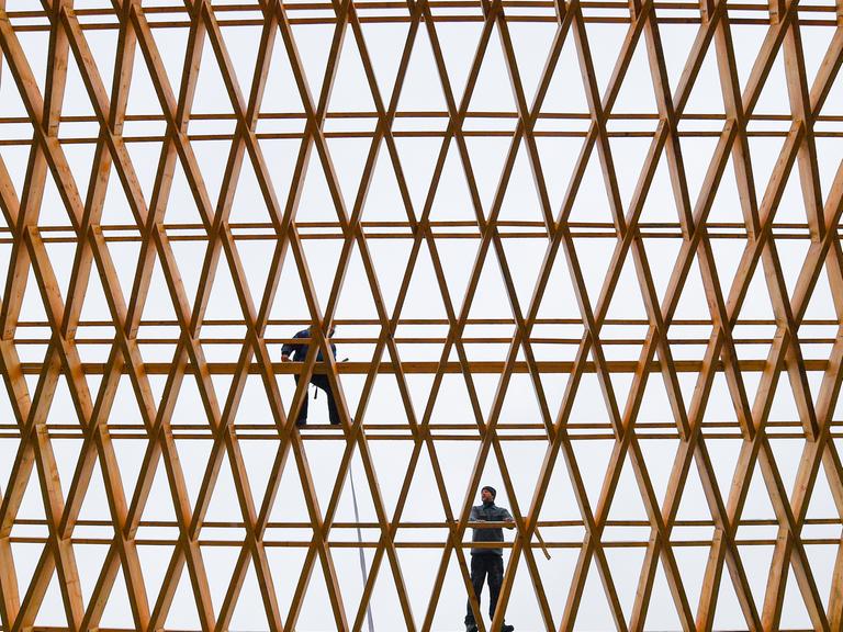 Zwei Mitarbeiter der Firma Elite Holzbau an der Dachkonstruktion einer Werkhalle